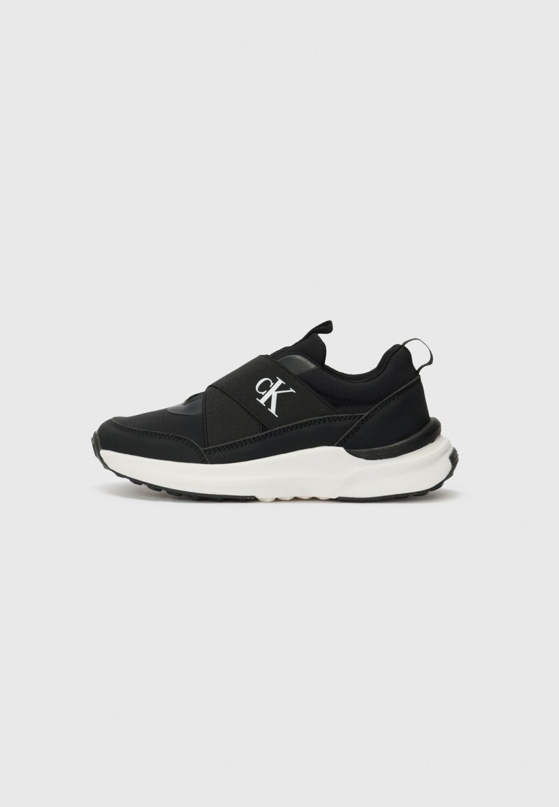 Black athletic shoes featuring a smooth textured upper, elastic band over the instep, and a white sole with a deep tread for traction.