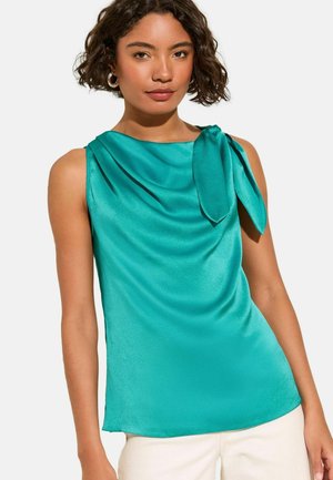 Turquoise sleeveless top with a cowl neckline and a tied accent on the left shoulder, made of smooth, shiny fabric.
