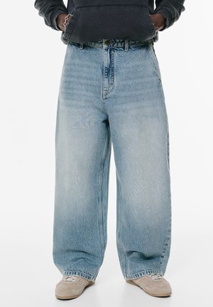 Light blue wide-leg jeans made of denim feature a high waist, classic five-pocket design, and visible stitching details.