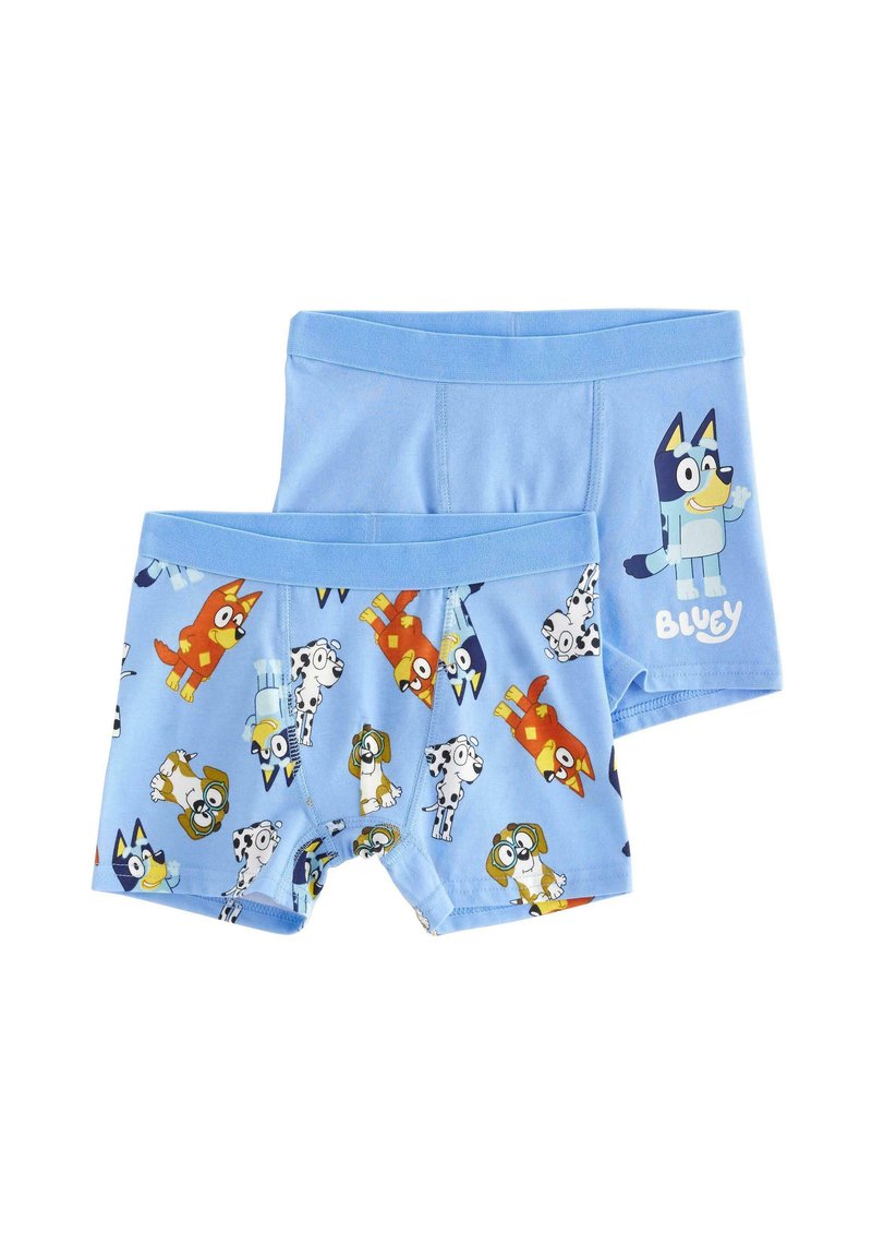 Blå bomullshorts med färgglada serietecken, inklusive en blå hund, på en lekfull, ljusblå bakgrund.