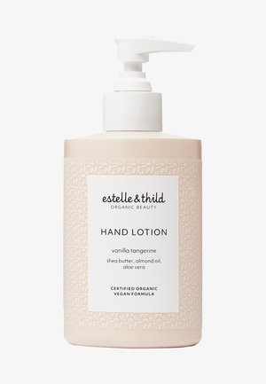 Botella de bomba de mano con loción, ligera y de color rosa, con un patrón floral. Presenta una etiqueta blanca con el nombre del producto y los ingredientes. Base antideslizante.