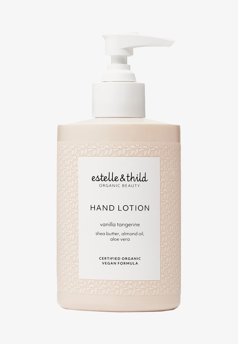 Botella de bomba de mano con loción, ligera y de color rosa, con un patrón floral. Presenta una etiqueta blanca con el nombre del producto y los ingredientes. Base antideslizante.