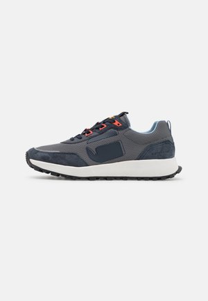 Men's sneakers in dark gray mesh and suede, featuring orange laces, a blue accent at the heel, and a textured rubber sole.