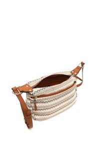 Texturerad krämfärgad väska med bruna detaljer, med ett zickzackmönster, dragkedja upptill och en avtagbar axelrem.