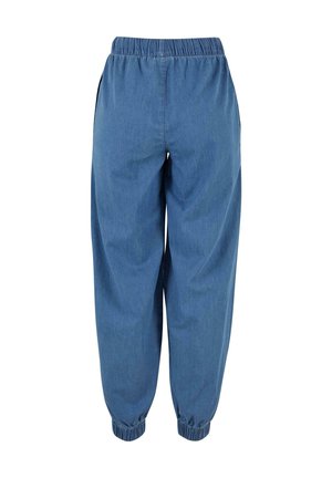 Volné modré džínové tepláky s elastickým páskem a manžetami, pohled zepředu na bílém pozadí.