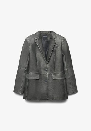 Blazer gris structuré avec une texture lisse, deux poches avant, fermeture à un bouton et détails de couture contrastants. Étiquette : Calliope.