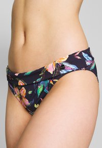 Gėlėmis raštuotas bikini apatinis trikotažas su tamsiu fonu, ryškiomis spalvomis, minkšta medžiaga ir sulankstoma juosmens juosta su logotipo etikete.