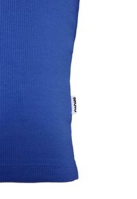 Niebieska poduszka o teksturowanym pokrowcu z żebrowanej tkaniny oraz widoczną czarno-białą metką marki z boku.