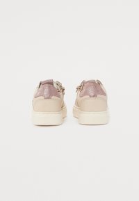 Baskets rose pâle avec un accent pailleté en or rose au niveau du talon, affichant un dessus lisse et une semelle en caoutchouc blanche.