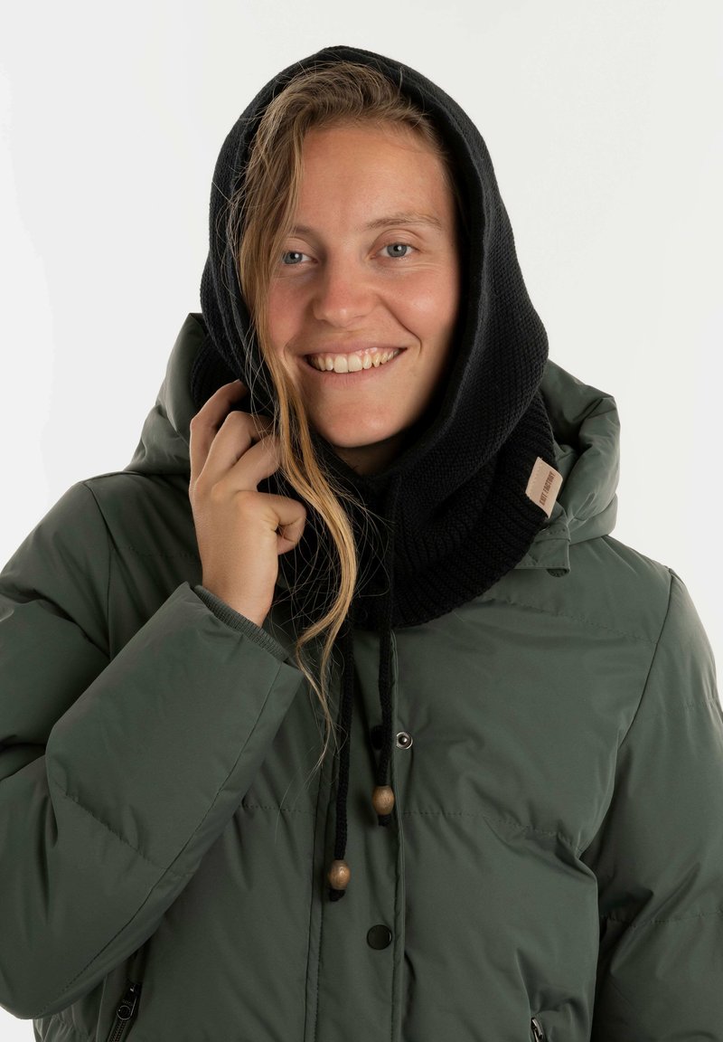 Groene gewatteerde jas met een zwarte gebreide capuchon. Voorzien van houten toggles en een zachte textuur, die warmte en comfort biedt.