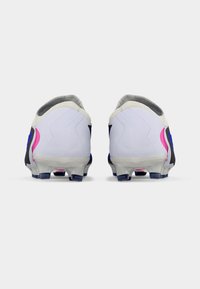 Ποδοσφαιρικά παπούτσια με λευκό επάνω μέρος, μαύρες λεπτομέρειες, ροζ και μπλε διακοσμήσεις, υφασμένο κολάρο και διαφανές εξωτερικό πέλμα με τάπες για πρόσφυση.