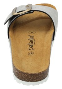 Sandale à glissière noire et argentée avec un dessus texturé, une semelle en liège et une semelle blanche. Comprend une boucle en métal et un logo embossé sur la semelle.