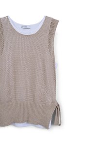 Top senza maniche in maglia beige con lavorazione a trama incrociata, sovrapposto a una camicia interna bianca, caratterizzato da un orlo a coste e lacci laterali.