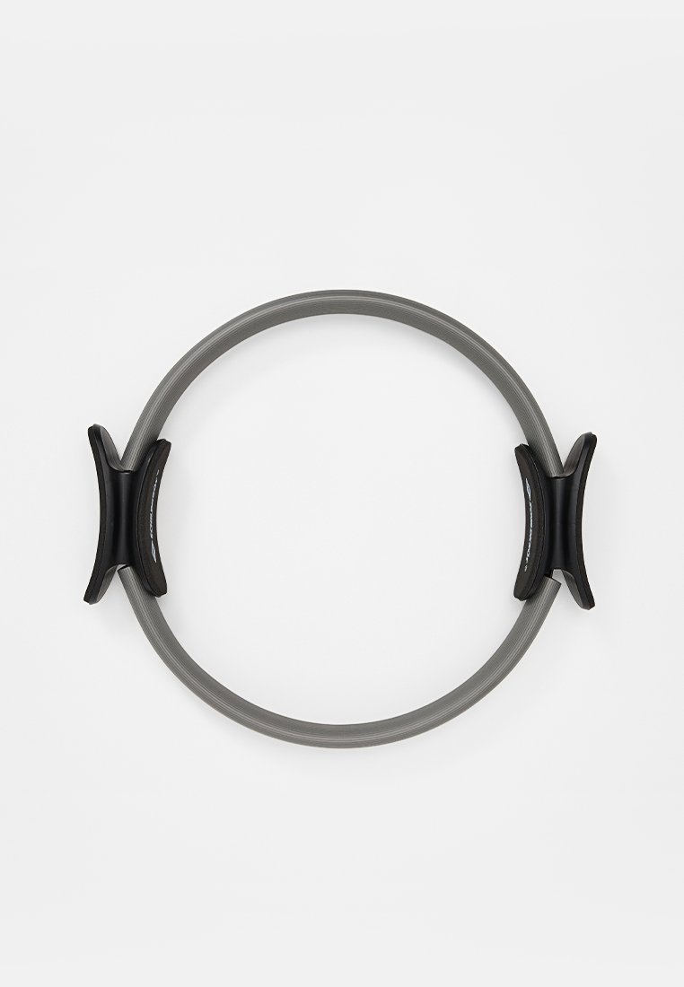 Anillo de pilates con un cuerpo flexible en gris y dos empuñaduras de goma negra en lados opuestos. Forma circular con una textura suave.