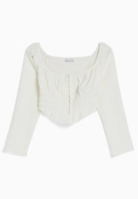 Blusa corta bianca a maniche lunghe con texture arricciata, scollatura quadrata e discreto dettaglio della cucitura anteriore.