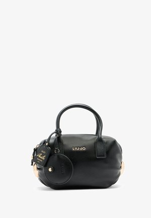 Sac à main en cuir noir texturé, de forme arrondie, avec des poignées courtes, des accents en matériel doré, et une étiquette circulaire attachée arborant le logo de la marque.