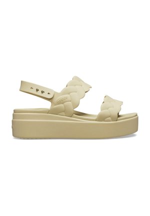 Beige platform sandal with braided straps and adjustable ankle strap, featuring a thick sole and open-toe design.