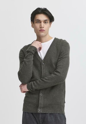 Khaki green wool cardigan with a v-neck, long sleeves, and two front buttons. Textured knit fabric with ribbed cuffs and hem.