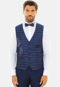 Gilet di satin blu navy con pattern testurizzato, cinque bottoni e due tasche, abbinato a una camicia bianca e un papillon coordinato.