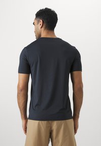 Tengerészkék, rövid ujjú póló, kerek nyakkivágással, sima, könnyű anyagból készült. Illeszkedő fazonú, puha varrási részletekkel rendelkezik.