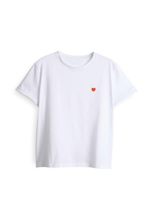 T-shirt blanc à manches courtes avec col rond et un petit cœur rouge brodé sur le côté gauche de la poitrine.