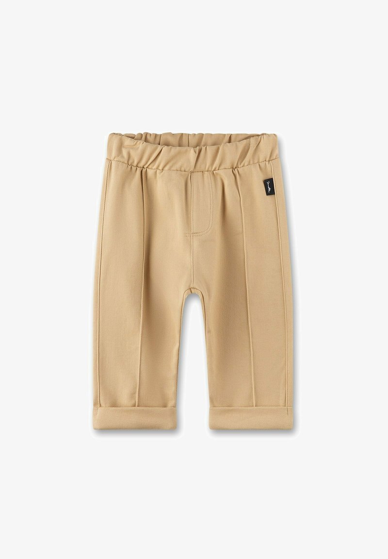 Pantaloni corti beige realizzati in materiale morbido, con un elastico in vita, bordi arrotolati e dettagli sulle cuciture frontali. Etichetta del marchio nera sul lato.
