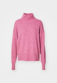 Pull à col roulé rose avec un tricot texturé, des épaules tombantes et des poignets côtelés. Le matériau semble doux et confortable, idéal pour le superposé.