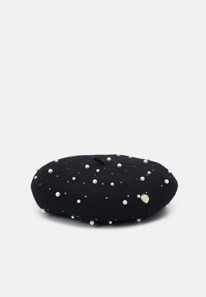 Czarna wełniana beret ozdobiona rozrzuconymi białymi perłami i małym metalowym zawieszkiem w kształcie serca na jednolitym tle.