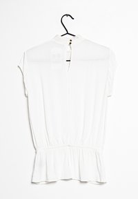 Blusa bianca a maniche corte con orlo peplum, dotata di chiusura a chiave sul retro e delicate decorazioni in pizzo attorno al décolleté.