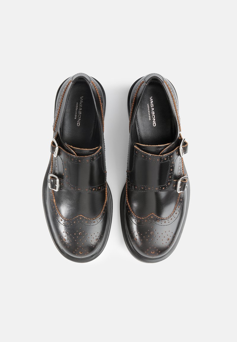 Scarpe in pelle nera con dettagli forati, accenti color cuoio e due fibbie argentate. Punta arrotondata e suola in gomma robusta.