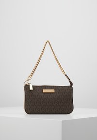 Bruine handtas met logo-patroon, goudkleurige schouderriem, ritssluiting en een gouden metalen merklabel aan de voorkant. Gladde textuur.