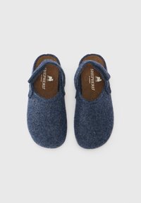 Blå filtklossar med öppen bak, rundade tår och en mjuk textur. Har en varumärkesetikett inuti med en enkel design.