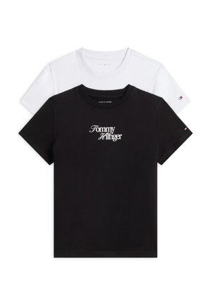 Deux T-shirts à manches courtes pliés, un noir avec un texte blanc "Tommy Hilfiger", et un blanc uni, tous deux avec un petit logo de marque sur la manche.