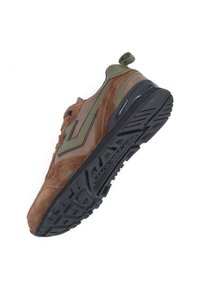 Baskets en suède marron et vert avec un design texturé, une semelle en caoutchouc noir, et une languette au talon pour un enfilage facile.