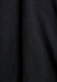 Svart tyg med en slät, något strukturerad yta. Materialet verkar lätt och faller mjukt, vilket framhäver dess mångsidiga användning.