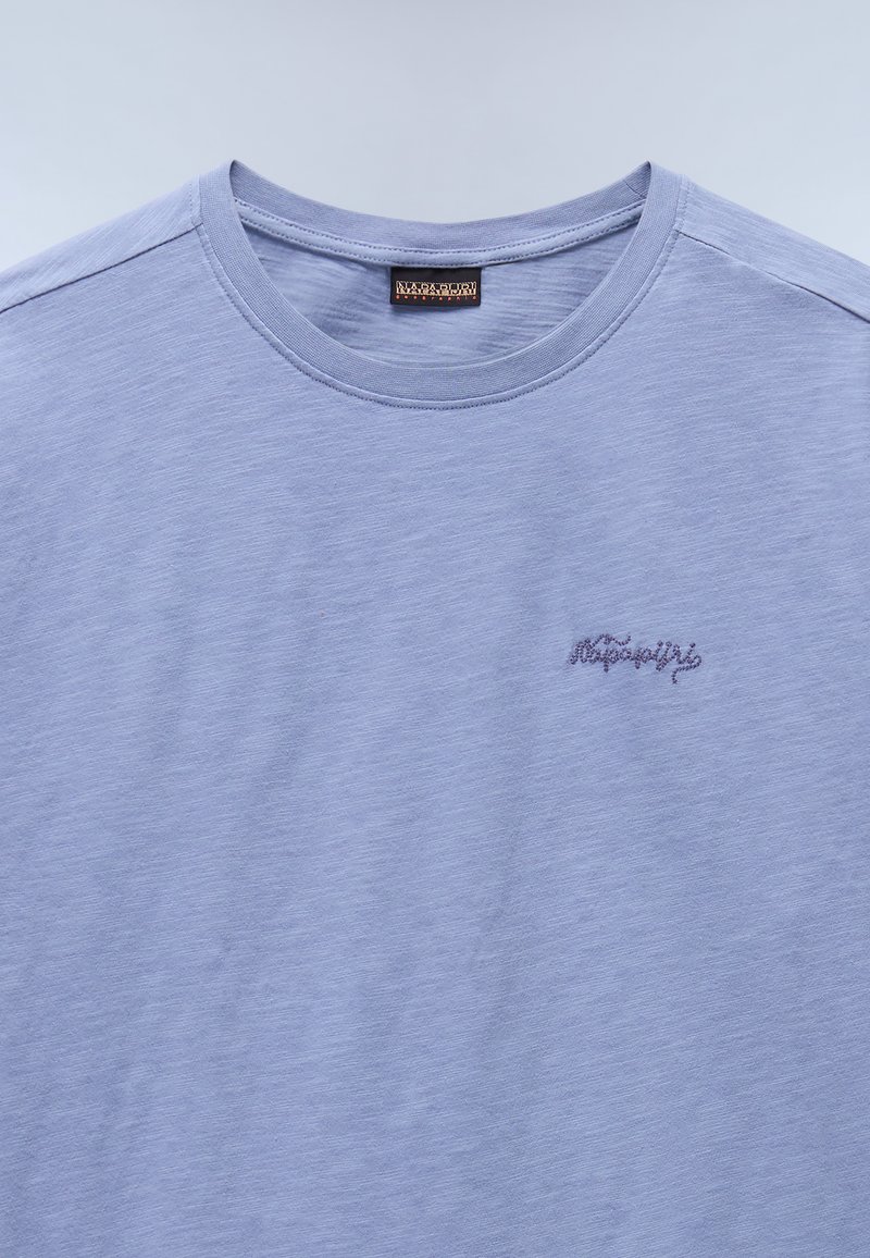 Hellblaues T-Shirt aus weichem Stoff, mit Rundhalsausschnitt, kurzen Ärmeln und einem kleinen gestickten Logo auf der linken Brust.