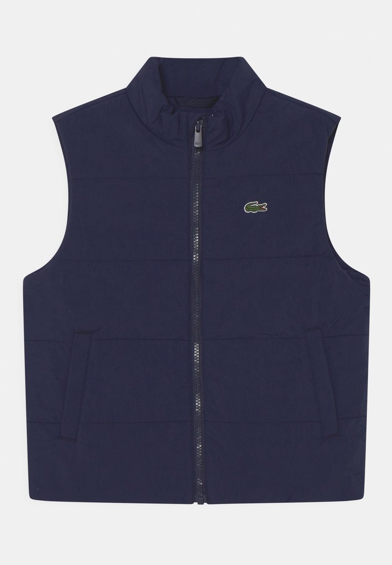 Gilet gonfiabile blu navy con colletto alto, zip frontale e due tasche laterali. Presenta un piccolo logo di coccodrillo verde sul lato sinistro del petto.