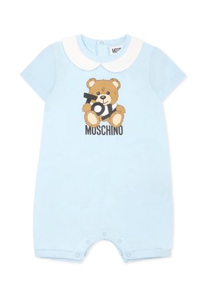 Lyseblå babyheldragt med hvid rundet krave, bamse, der holder bogstaverne "Toy", og teksten "Moschino" nedenunder. Trykknapper ved benene.