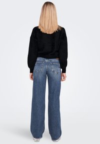 Black, textured knit sweater paired with wide-leg blue denim jeans. The jeans feature a classic five-pocket design and a high waist.