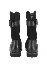 Schwarze Wildleder- und Leder-Ankelboots mit einer robusten Sohle, die ein breites Lederband und eine Schnallen-Detailierung im oberen Bereich aufweisen.