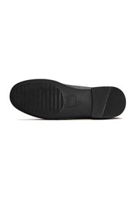 Zwarte rubberen zool met horizontale groeven, afgeronde hak en reliëflogo. Gladde textuur en plat profiel voor stabiliteit en grip.