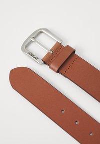 Cinturón de cuero marrón con una hebilla de metal plateado. Presenta una textura suave, costura simple y el nombre de la marca "REPLAY" grabado en la hebilla.