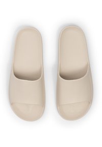 Infradito beige con punta aperta, soletta testurizzata e superficie liscia. Design leggero e minimalista, adatto per un abbigliamento casual.