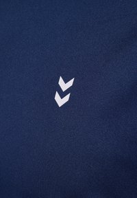 Navyblauwe stof met een wit logo dat bestaat uit twee naar beneden wijzende chevronvormen, een gladde textuur en geen zichtbare patronen of accenten.