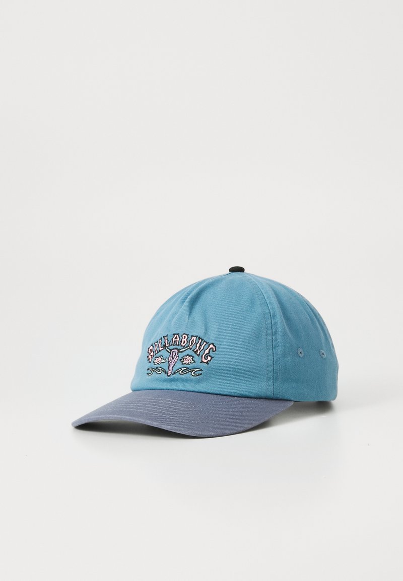 Casquette de baseball bleue et grise avec le logo brodé "Billabong" et un motif vague sur le devant, exposée sur une surface blanche.