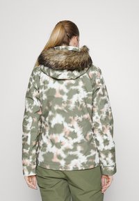 Tarnjacke in Grün, Pink und Weiß, mit einem gefütterten Kapuzenkragen, einer glatten Textur und einer lockeren Passform.