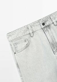 Lysegrå denimjeans med et klassisk fem-lommers design, der har lynlås og bæltestropper. Subtil struktur med synlige sømdetaljer.