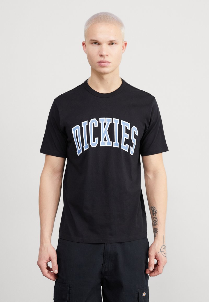 Černé bavlněné tričko s modro-bílým prohnutým logem "DICKIES" na hrudi. Krátké rukávy a klasický kulatý výstřih.