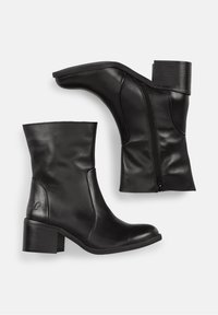 Botas de cuero negro hasta el tobillo con puntera redondeada, cremallera lateral y un bajo tacón cuadrado. Textura suave con un sutil logotipo en el lateral.