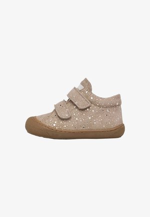 Chaussure beige pour tout-petit avec deux bandes Velcro, motif brillant et semelle ainsi que bout en caoutchouc marron, vue de côté.